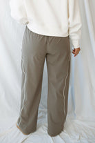 Model wearing the drawstring waist track pants in truffle. 