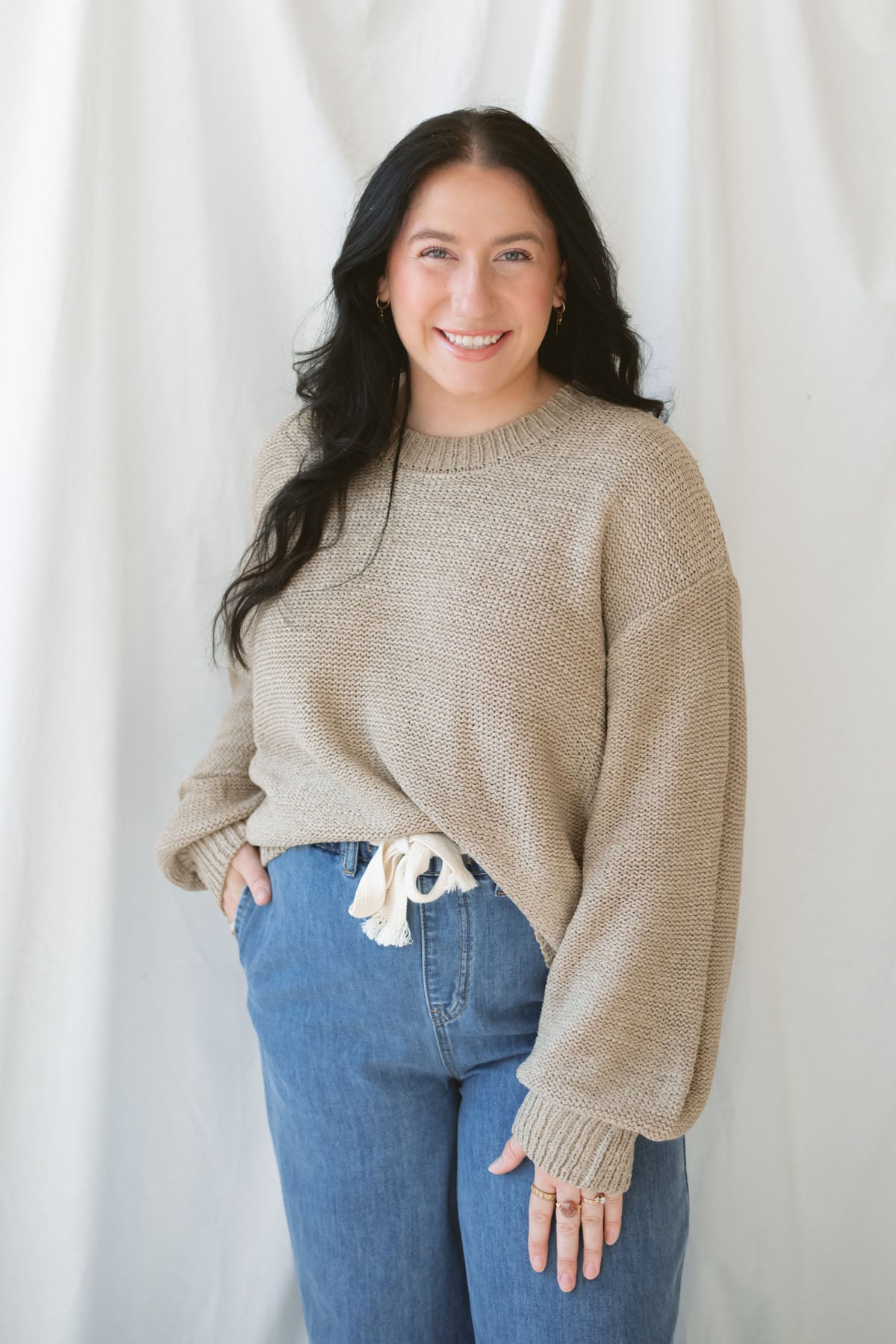 Model is wearing a soft knit round neck sweater with a balloon sleeve. 