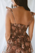 Model wearing the Floral Ruffle Dress in brown. A great fall wedding or event option.