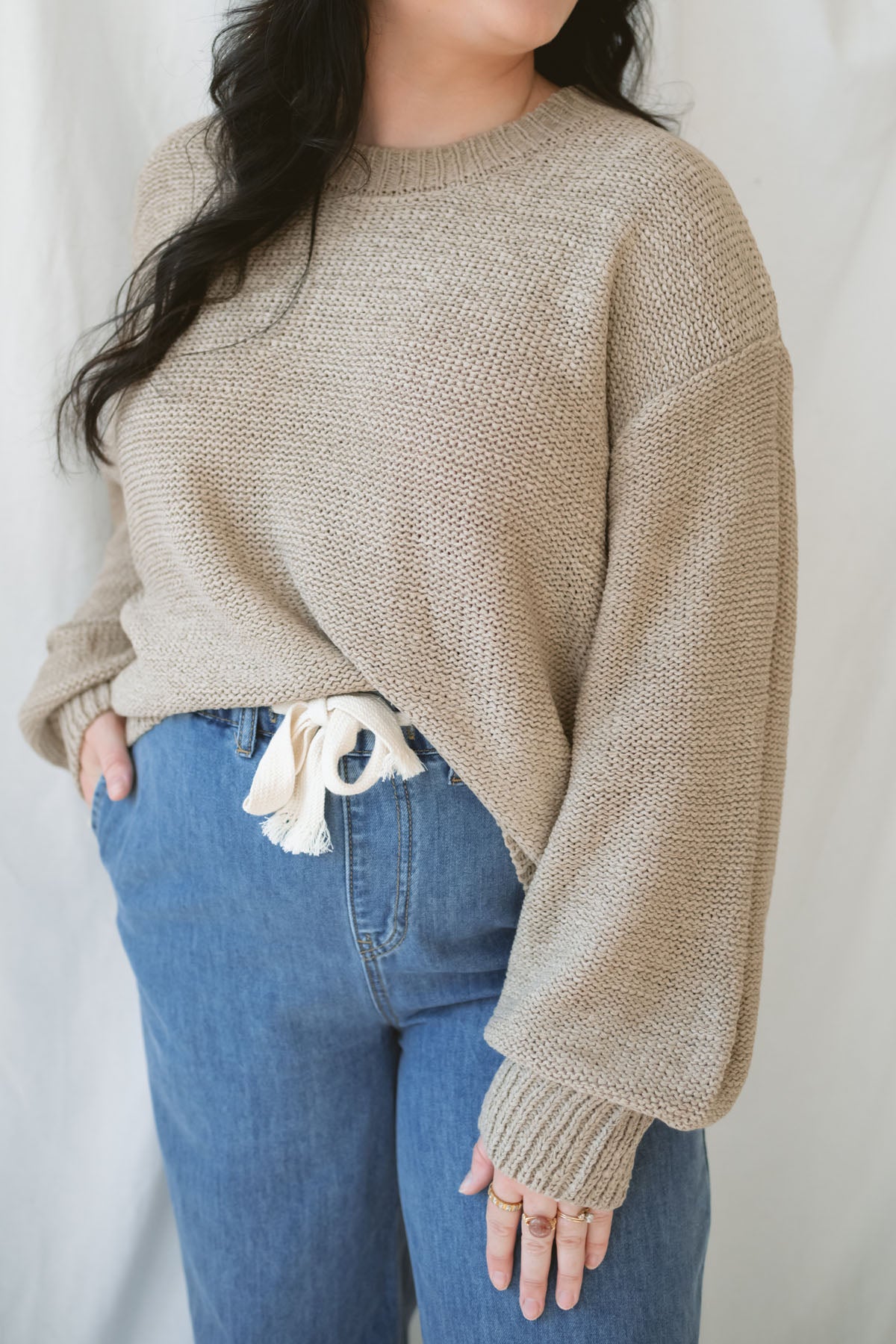 Model is wearing a soft knit round neck sweater with a balloon sleeve. 
