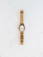 Snake band oval watch sitting on white marble board. 