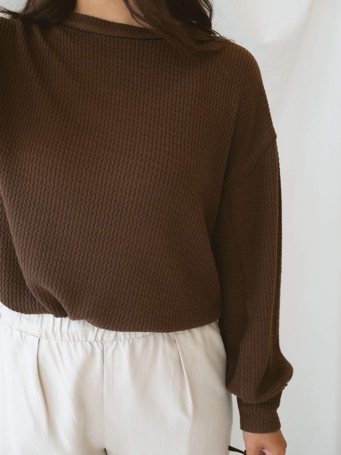 Model wearing textured top with exposed seam detail. A casual option that can be dressed up or down. 