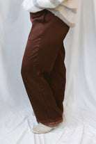 Brown satin wide-leg pants for women featuring delicate lace trim, a mid-waisted silhouette, and a smooth satin finish for elevated everyday styling.