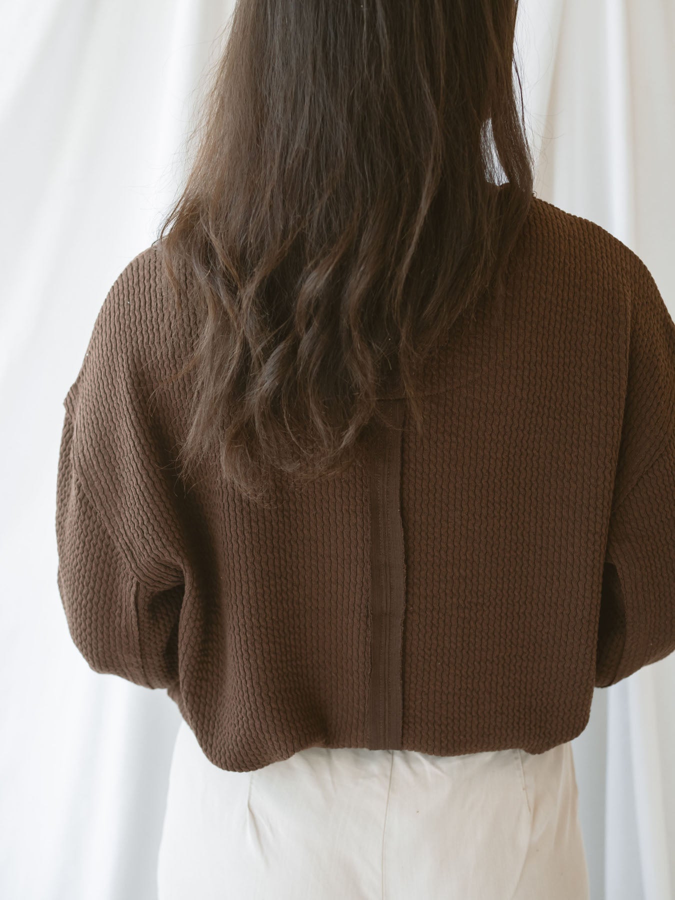 Model wearing textured top with exposed seam detail. A casual option that can be dressed up or down. 