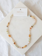 Handmade beaded necklace laying on marble board. 