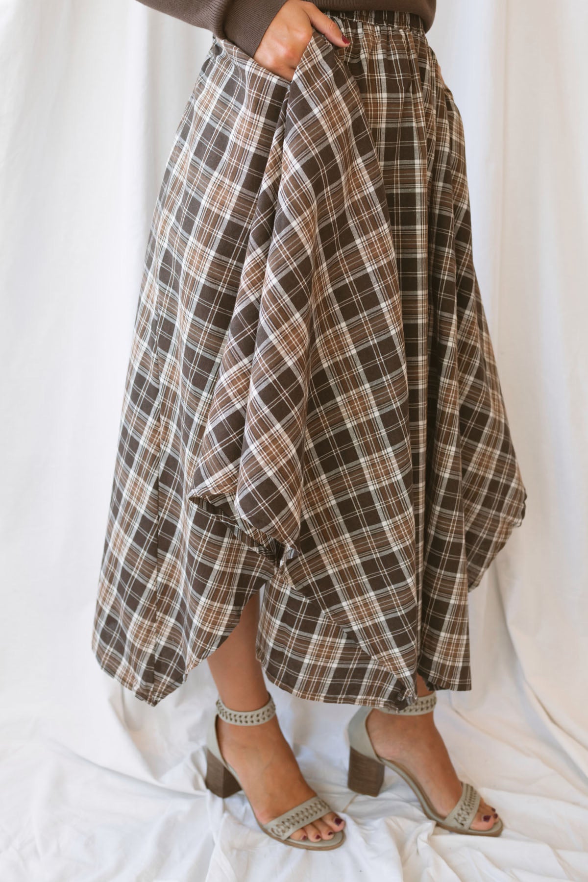 Riley brown plaid midi skirt with an asymmetrical hem and classic autumn pattern.