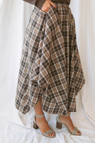 Riley brown plaid midi skirt with an asymmetrical hem and classic autumn pattern.