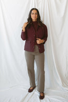 Model is wearing a quilted two tone jacket in burgundy. 