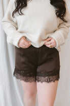 Autumn Waistband Lace Trim Hem Satin Shorts in brown with a smooth satin finish and delicate lace trim along the hem.