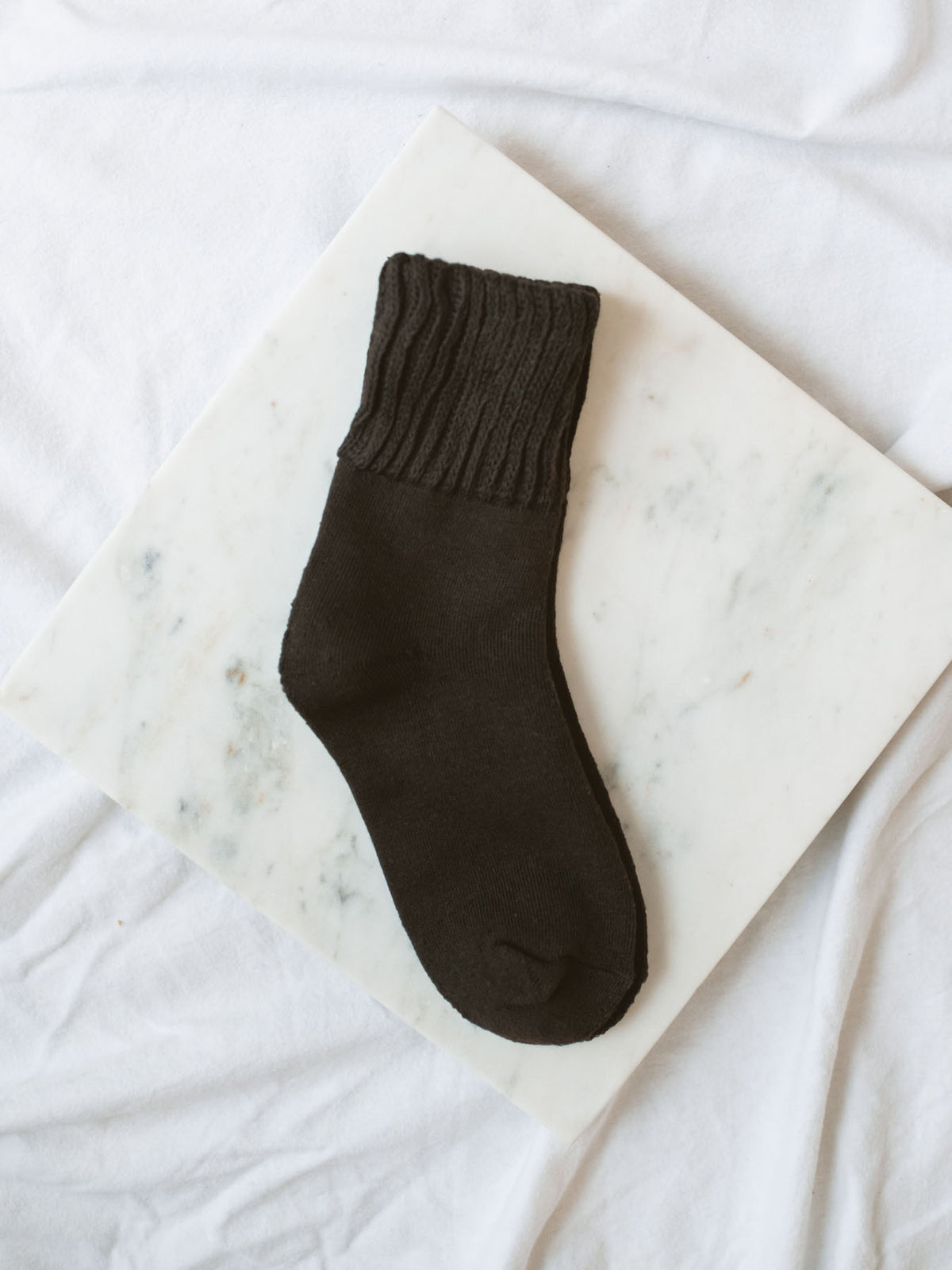 Dark Coffee Brown Colored Crew Socks laying on marble board. 