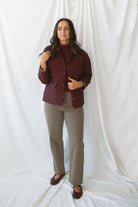 Model is wearing a quilted two tone jacket in burgundy. 
