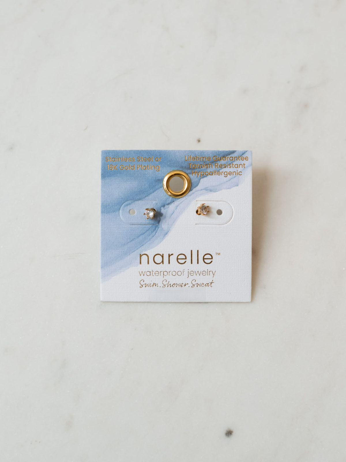 round cubic zirconia studs laying on marble board. 