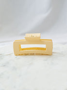 Matte Beige square claw clip sitting on marble board. 