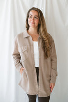 Model is wearing an oversized shacking in the color silken taupe. Model has it styled open with leggings and a tank. 