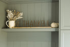 Be Thankful style metal and wood sign sitting on shelf styled with a pumpkin vase and foliage in addition to a knit beige pumpkin. 