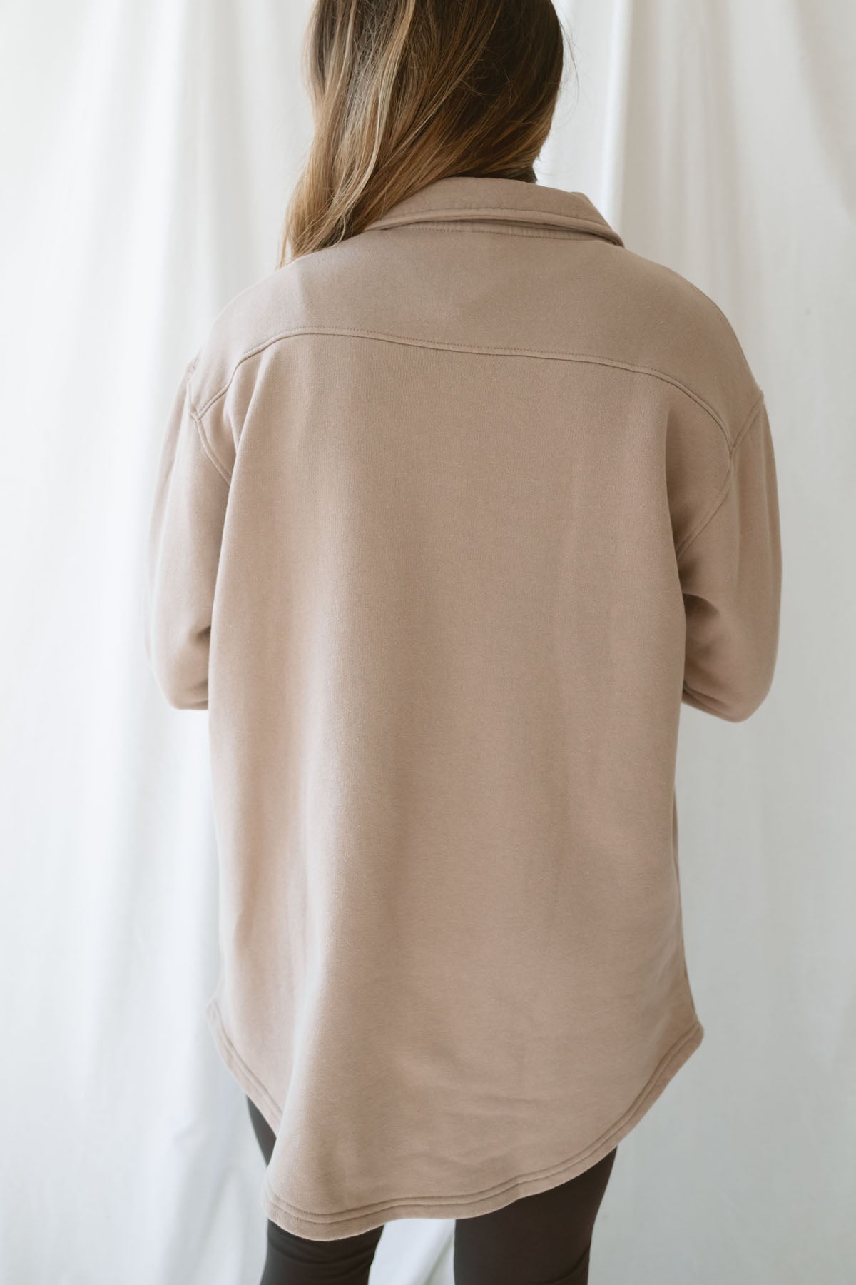 Model is wearing an oversized shacking in the color silken taupe. Model has it styled open with leggings and a tank. 