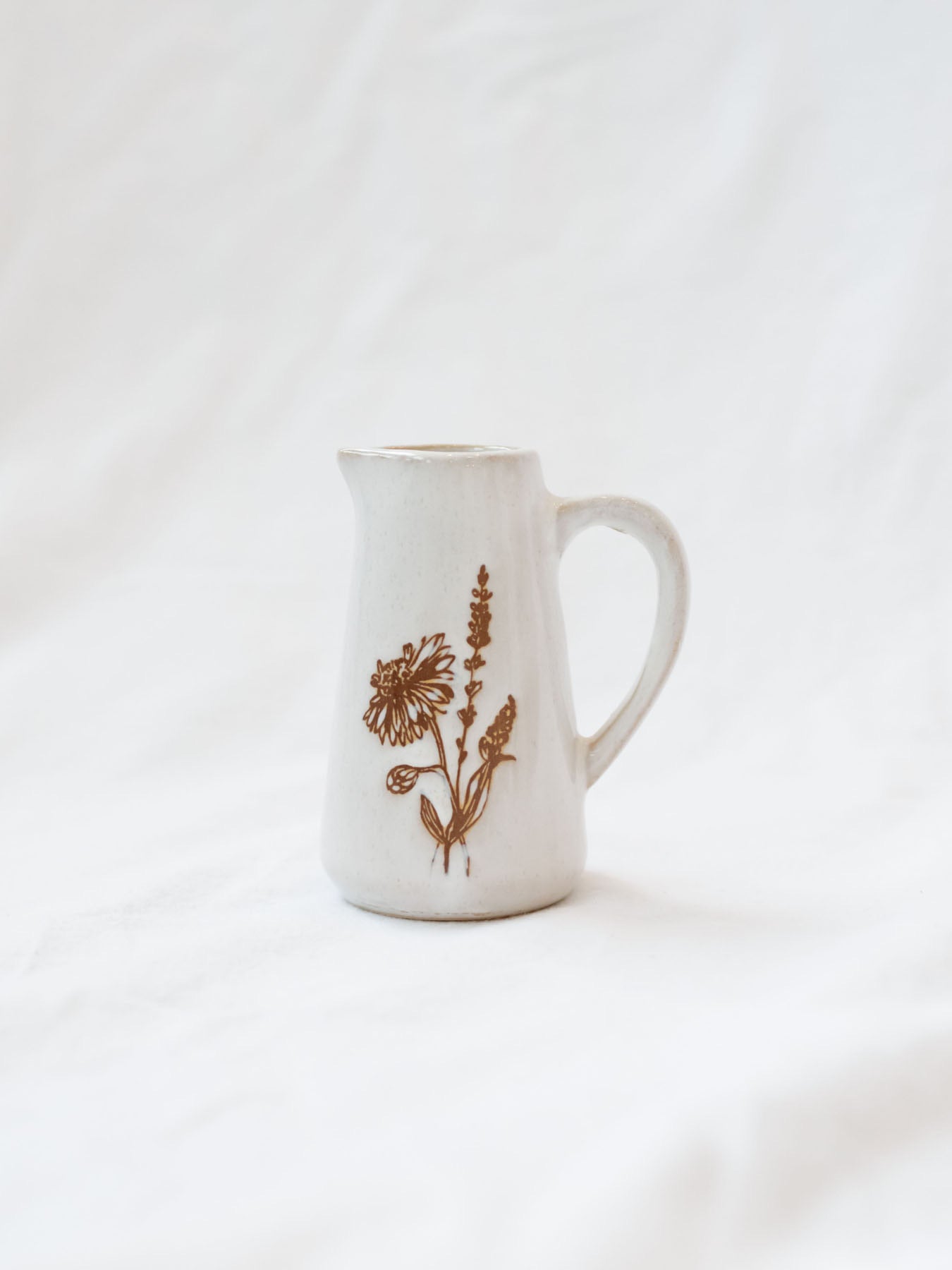 Style 2 of the mini floral pitcher. Set up against a white linen backdrop. 