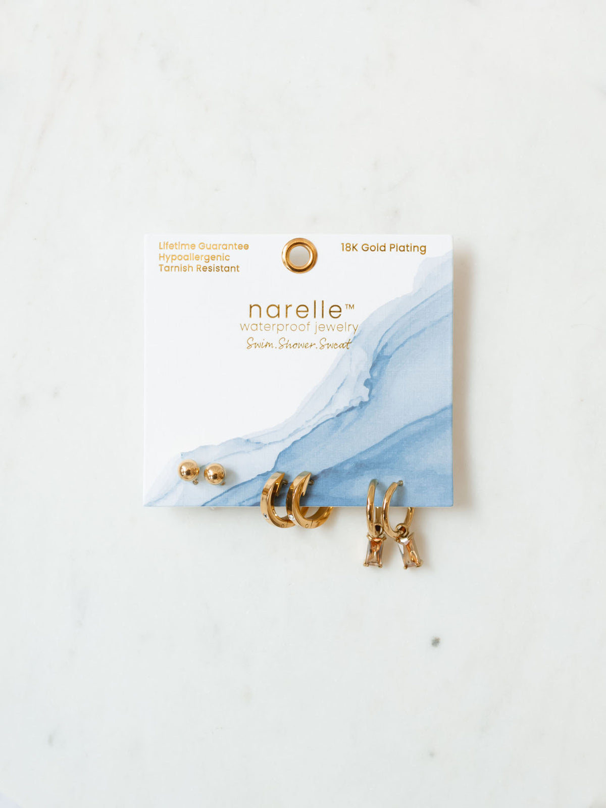 The rectangular trio pack of earrings sitting on white background. 