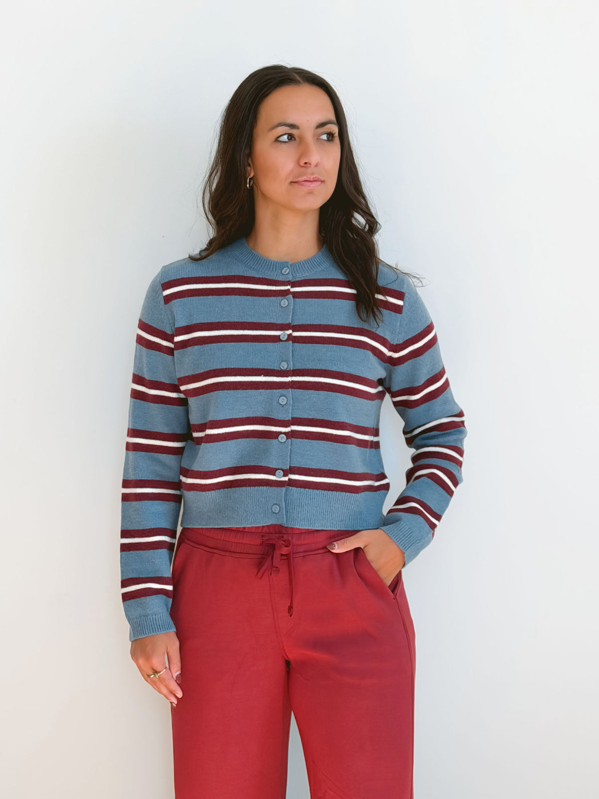 Model wearing long sleeve full button down striped cardigan.