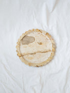 Top view of marble scallop edge tray sitting on white linen backdrop. 