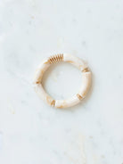 Cream chunky beaded stretch bracelet laying on marble board. 