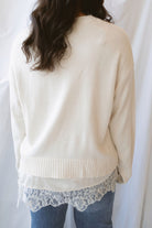 Traci cream knit long sleeve sweater top with a contrasting satin lace layered hem.