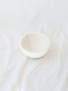 Small size of the marble bowls sitting in front of a white linen backdrop. 