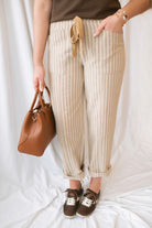 Steph Striped Wide Leg Drawstring Pants in Warm Sand Stripe featuring a relaxed silhouette and neutral striped pattern.