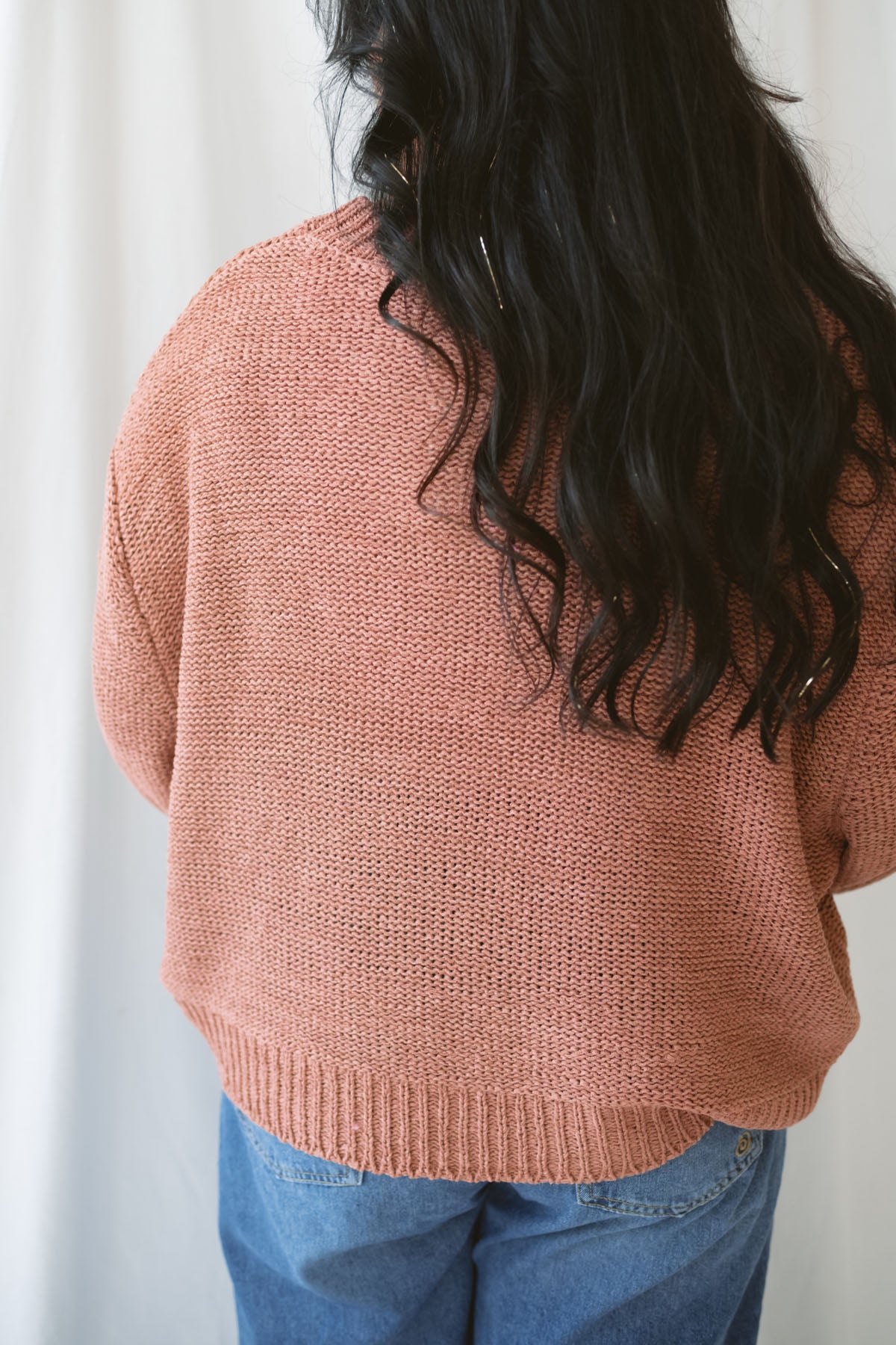 Model is wearing a round neck knit sweater featuring balloon sleeves 