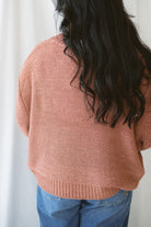 Model is wearing a round neck knit sweater featuring balloon sleeves 