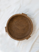 Top view of the footed cement bowl sitting on a white linen backdrop. 