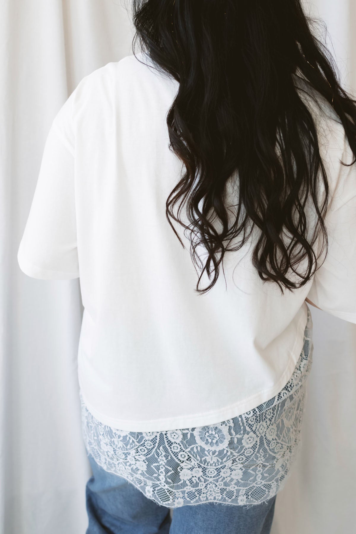Jane ivory T-shirt featuring delicate floral lace trim and an asymmetrical design.
