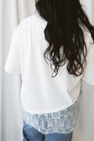 Jane ivory T-shirt featuring delicate floral lace trim and an asymmetrical design.