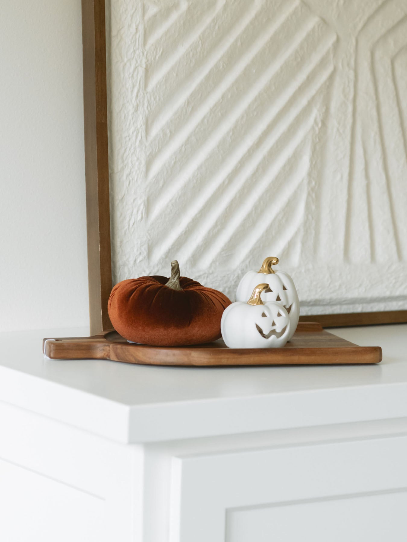 Rust color velvet pumpkin sitting on warm wood board paired with the mini LED Jack-o-lanterns for a warm and cozy fall look. 