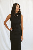 Model wearing pleat detail black midi dress.