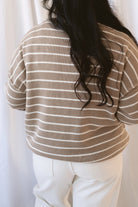 Selena taupe sweater with cream stripes, a relaxed drop shoulder fit, crew neckline, and long sleeves.
