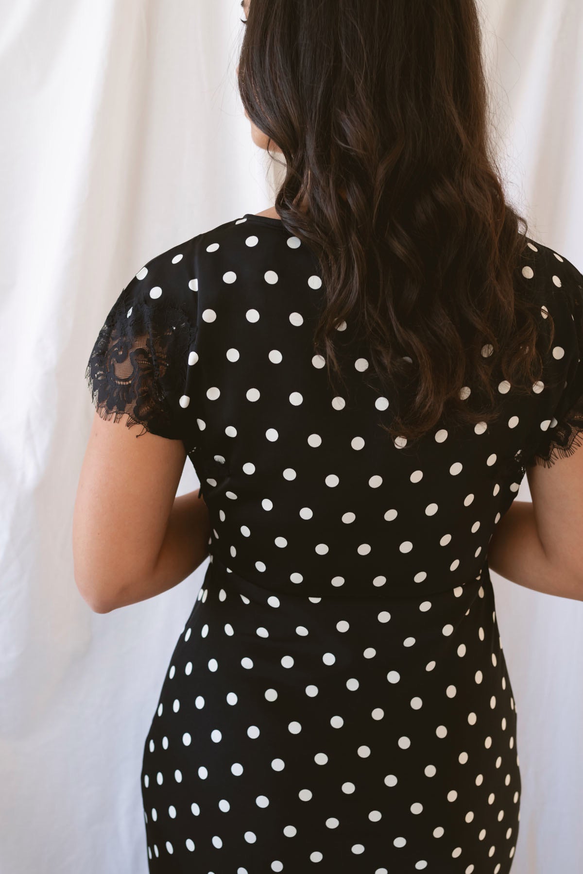Joanna black polka dot midi dress featuring short sleeves and delicate lace trim detailing.