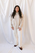Emily oatmeal fuzzy knit sweater with a raw-edge mock neckline and long sleeves.