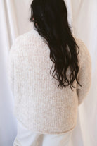 Emily oatmeal fuzzy knit sweater with a raw-edge mock neckline and long sleeves.