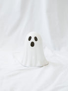 The larger taller style of the LED ceramic white ghost sitting on a white linen backdrop. 
