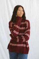 Model wearing an oversized stripe long sleeve sweater. 