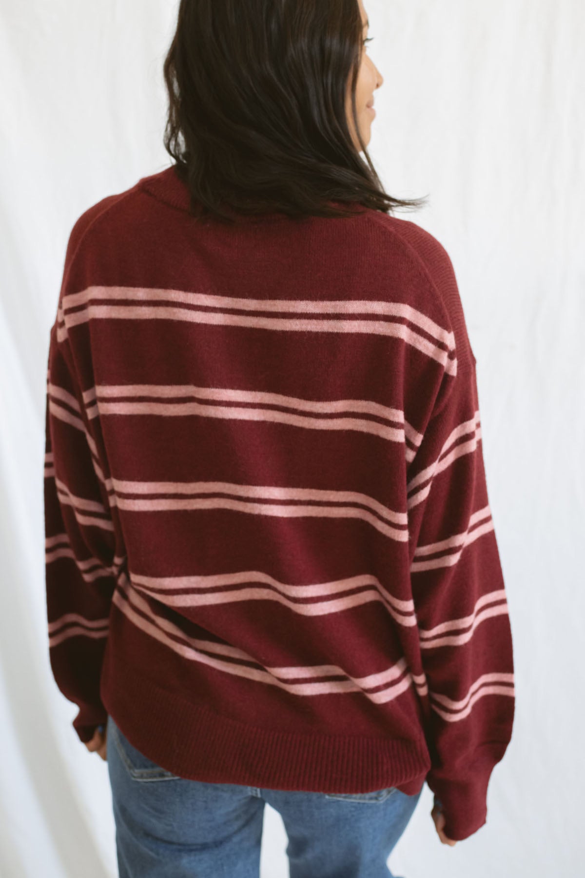 Model wearing an oversized stripe long sleeve sweater. 
