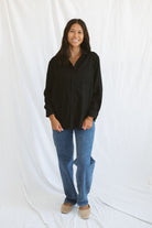 Model wearing classic black button up styled fully buttoned with a classic denim.