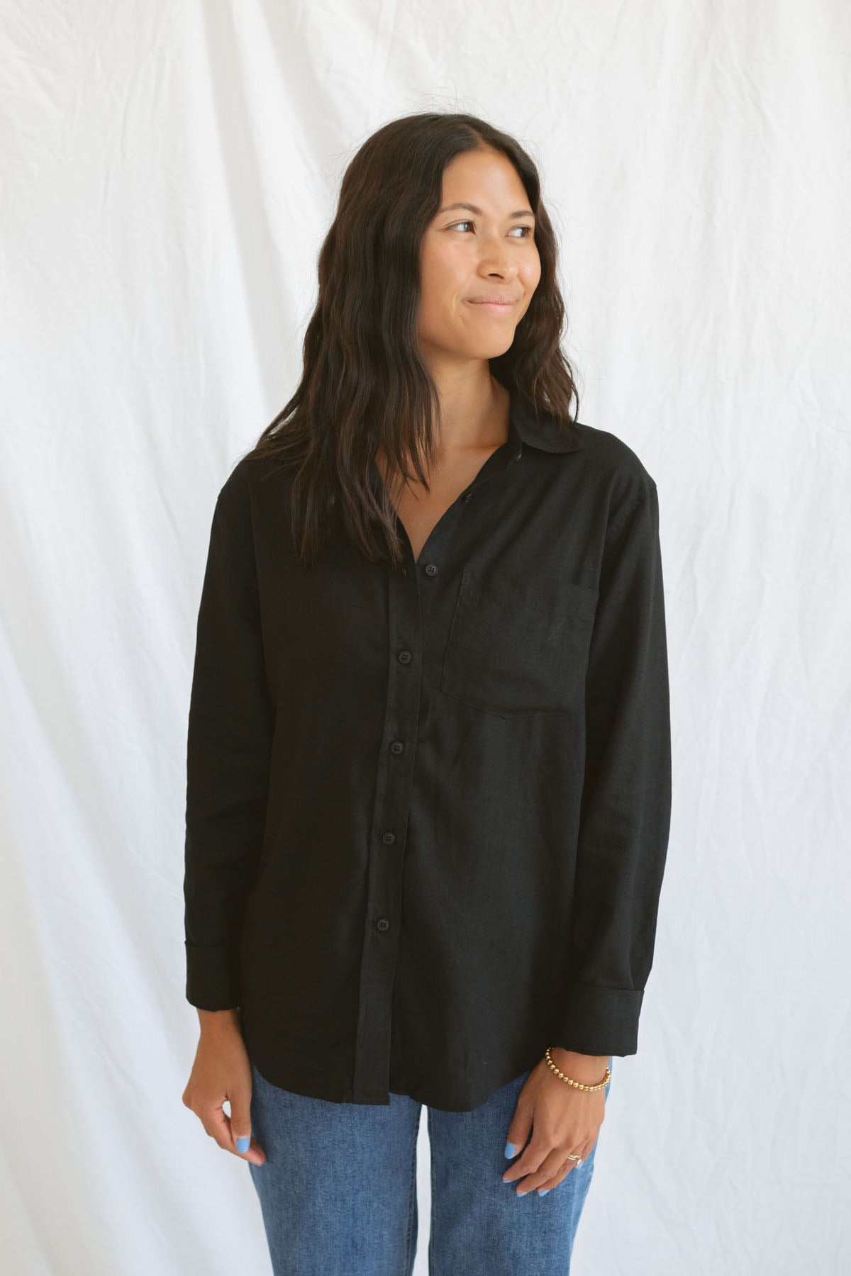 Model wearing classic black button up styled fully buttoned with a classic denim.