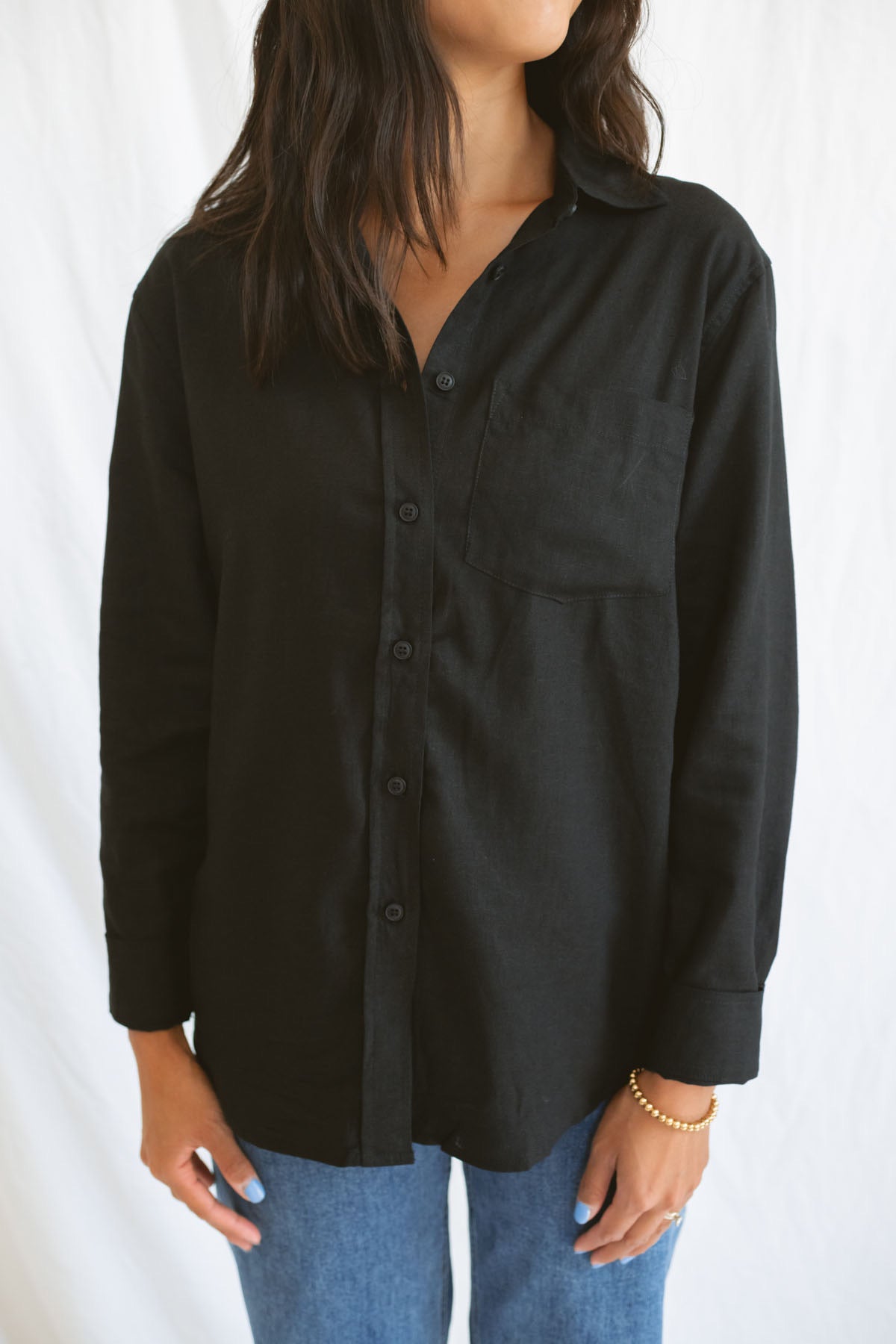 Model wearing classic black button up styled fully buttoned with a classic denim.