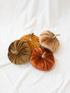 Larger size velvet pumpkins sitting in a pile to show the 4 different colors. 