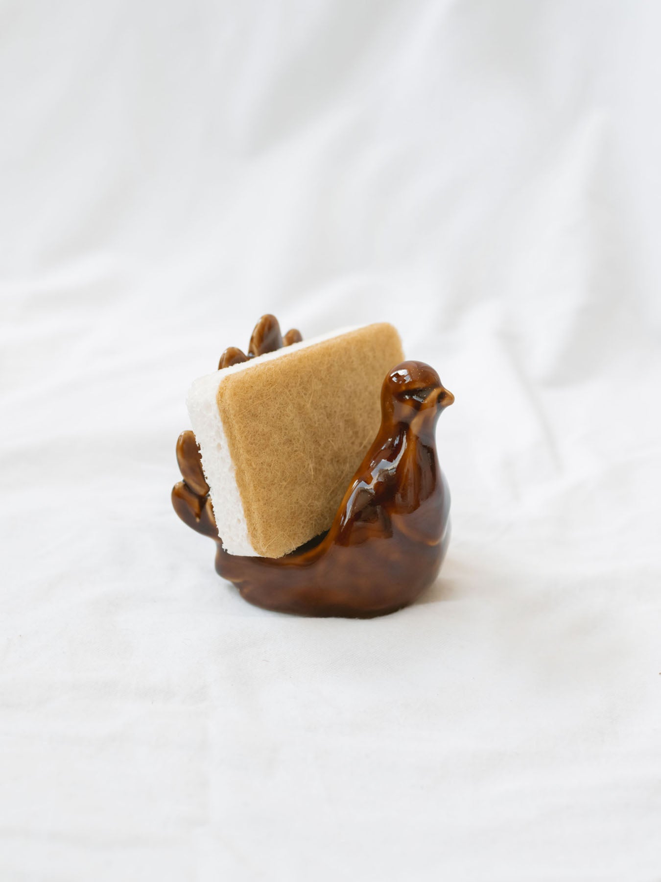 Turkey sponge holder with sponge sitting on white linen backdrop.